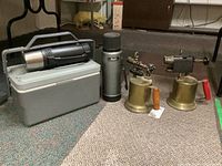 Photo showing the full lot including two blowtorches, two thermos bottles, and a grey lunch box on the floor.