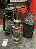 Set of 5 lanterns including punch tin lantern and 4 kerosene lanterns arranged on carpet, front view