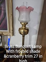 Brass banquet lamp with frosted glass shade and cranberry trim, 27 inches tall