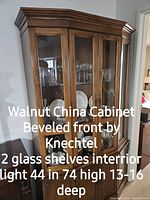 Walnut china cabinet with beveled front glass and interior shelves, illuminated by internal light, showing dimensions and details.