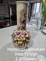 Handmade porcelain vase, approximately 11 inches tall, crackled grey base with detailed 3D floral decoration in pastel colors.