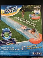 Photo of original packaging showing the surfaces and length of the water slide with children playing