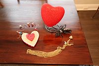 Photo shows red heart lamp, wireless wooden heart decoration with beads, and gold-tone chains with pendant on a wooden surface
