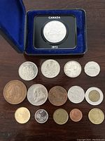 1972 Canadian silver dollar in blue velvet display case with assorted coins arranged below