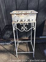 Full view of the vintage metal plant stand showing tall slender legs and intricate grapevine leaf pattern