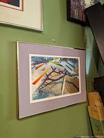 Framed abstract serigraph artwork mounted on wall, showing colorful geometric and organic elements.
