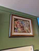 Framed original abstract painting displayed on a green wall with a visible price tag on the bottom right corner of the frame.