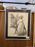 Framed black and white print showing three penguins with a price tag of $39 on the lower right corner.