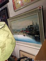 Framed signed original oil painting showing a harbor scene with boats and buildings, emphasizing the artwork and frame condition