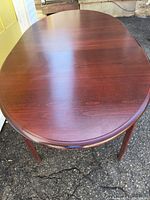 Top view of oval cherry wood dining table showing wood grain and finish
