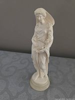 Front view of the standing white stonelite figurine showing detailed classical female figure and marble base.
