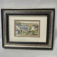 Framed watercolor painting of rural stone buildings with slate roofs in a countryside farm scene.
