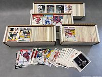 Overview shot showing three boxes filled with hockey cards and several loose cards spread out in front for viewing.