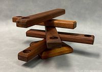 Side angle of wooden folding candle holder showing five bars with candle indentations and how they intersect.