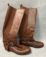Side view of both Ralph Lauren tall brown leather boots showing the elastic panel and ankle strap details.