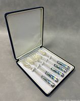 Set of 5 vintage forks with cloisonné handles in original velvet-lined box, arranged neatly with fork tines facing up.
