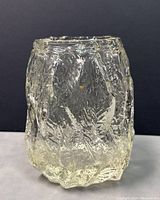 Close-up view showing the textured, rough surface of the clear glass vase with natural organic patterning and minor yellowish tint.