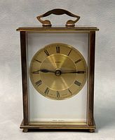 Front close-up of the vintage Metamec brass table clock showing the dial with Roman numerals and clock hands.