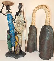 Front view of the African tribal family statue and double gong bell showing details of color and finish.