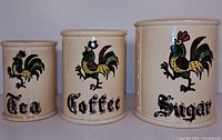 Front view of three ceramic canisters labeled Tea, Coffee, and Sugar with painted rooster design