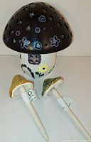 Mindware fairy mushroom house light with painted details, decorative cutouts including stars, hearts, circles, and small windows with flowers on white base.
