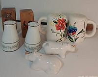 Five salt and pepper shakers shown together including rhino, flower, daisy, and rooster designs