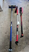Three adjustable auto snow brushes with scrapers laid on concrete floor