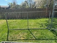 Front view of the Lynx free-standing chainlink fence panel set on grass, showing metal frame and chainlink mesh with two vertical support bars.