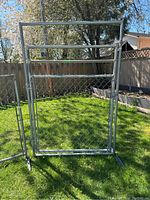 Full view of the free-standing chainlink gate outdoors showing metal frame and chainlink mesh attached, with metal base for support