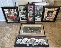 All seven framed pictures displayed on floor showing a variety of scenes including puppies, geese, bench with flowers, window, and prints.