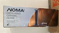 Original packaging box of Noma oscillating ceramic heater showing product image and features.