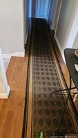 Full length of the hallway runner laid along the floor highlighting its pattern and location in a hallway.