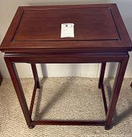 Front view of rectangular wooden side table on carpet, showing structure and leg design.