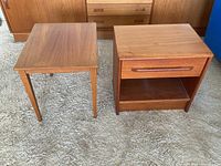 Photo showing two wooden tables side by side on a carpeted floor including the drawer detail on the right table.