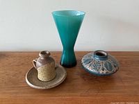 Front view of all three items showing their size and relative position on wooden surface.