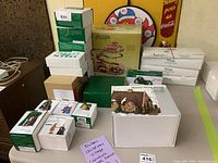 Overview of stacked Department 56 boxes and gold label roller coaster box on table