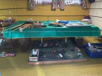 Full view of pool table covered by green vinyl cover