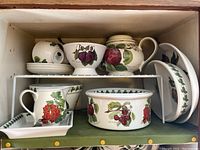 Full view of two-shelf cabinet showing assortment of Portmeirion Botanic Garden pieces