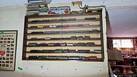 Wall-mounted wooden shelf with approx. 50 HO scale model trains displayed on 7 shelves