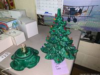 Photo of ceramic Christmas tree and electric base on table showing bulb arrangement and power cord.