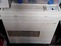 Front view showing vent grille, control panel, housing