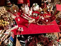 Overview of lot items on table showing multiple vintage Christmas decorations including angels, reindeer sleigh, berries, garlands, and assorted figurines.