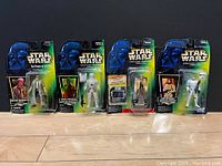 Four new, unopened vintage Star Wars action figures in original blister packaging on black background.