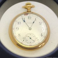 Front view of the Waltham pocket watch showing the porcelain dial with black and red numerals, two hands, and sub-second dial.