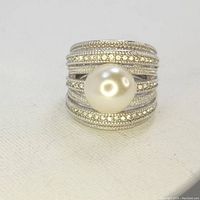 Front view showing the large pearl center and multiple rows of marcasite stones on the wide silver band.