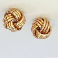 Close up photo of one knot style gold tone vermeil stud earring, showing intricate looped design.