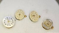 Four Geneve Geneva watch movements in removed from cases, showing dials and crowns for detail.