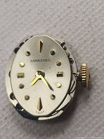 Front close-up of the Longines watch movement showing the applied gold hour markers and gold-tone hands.