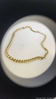 Photo of a vintage men's gold-tone chain necklace laid flat showing the full length and clasp.
