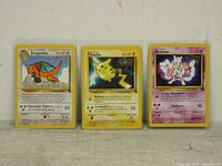 Front view of three Pokemon movie cards featuring Dragonite, Pikachu, and Mewtwo with visible details of attacks and HP.